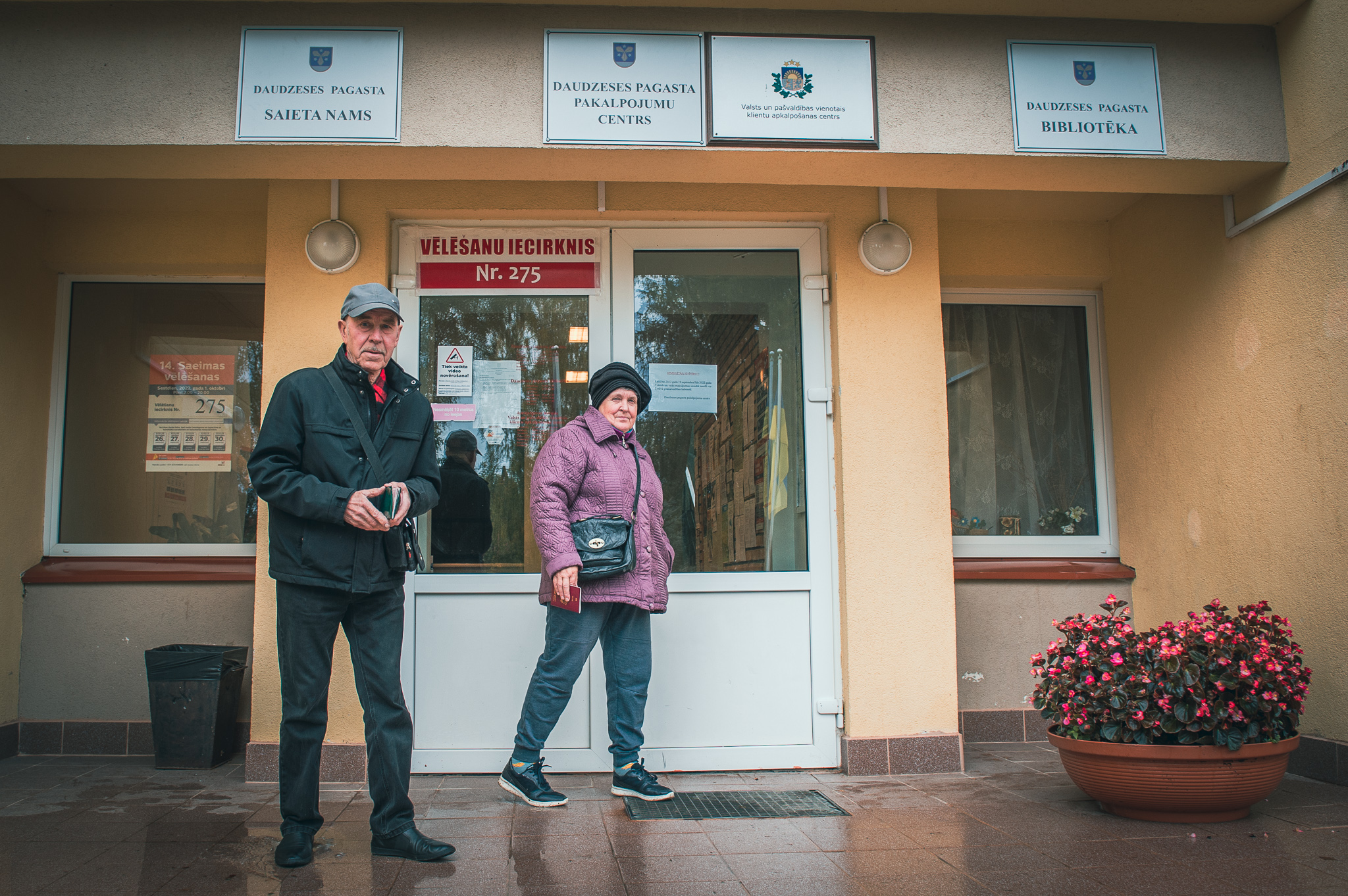 Divi cilvēki iznāk no vēlēšanu iecirkņa Daudzeses pagasta Saieta namā