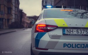 Latvijas Valsts policijas dienesta automašīna uz ielas ar ieslēgtām bākugunīm