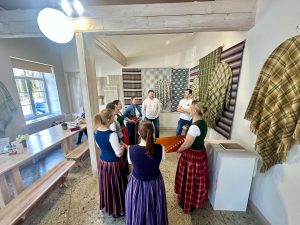 Sievietes latviešu tautastērpos dzied un spēlē kokli tradicionālā kultūras pasākumā