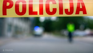 Policijas lentu uzstādījums uz ceļa, fonā redzams policijas transports.
