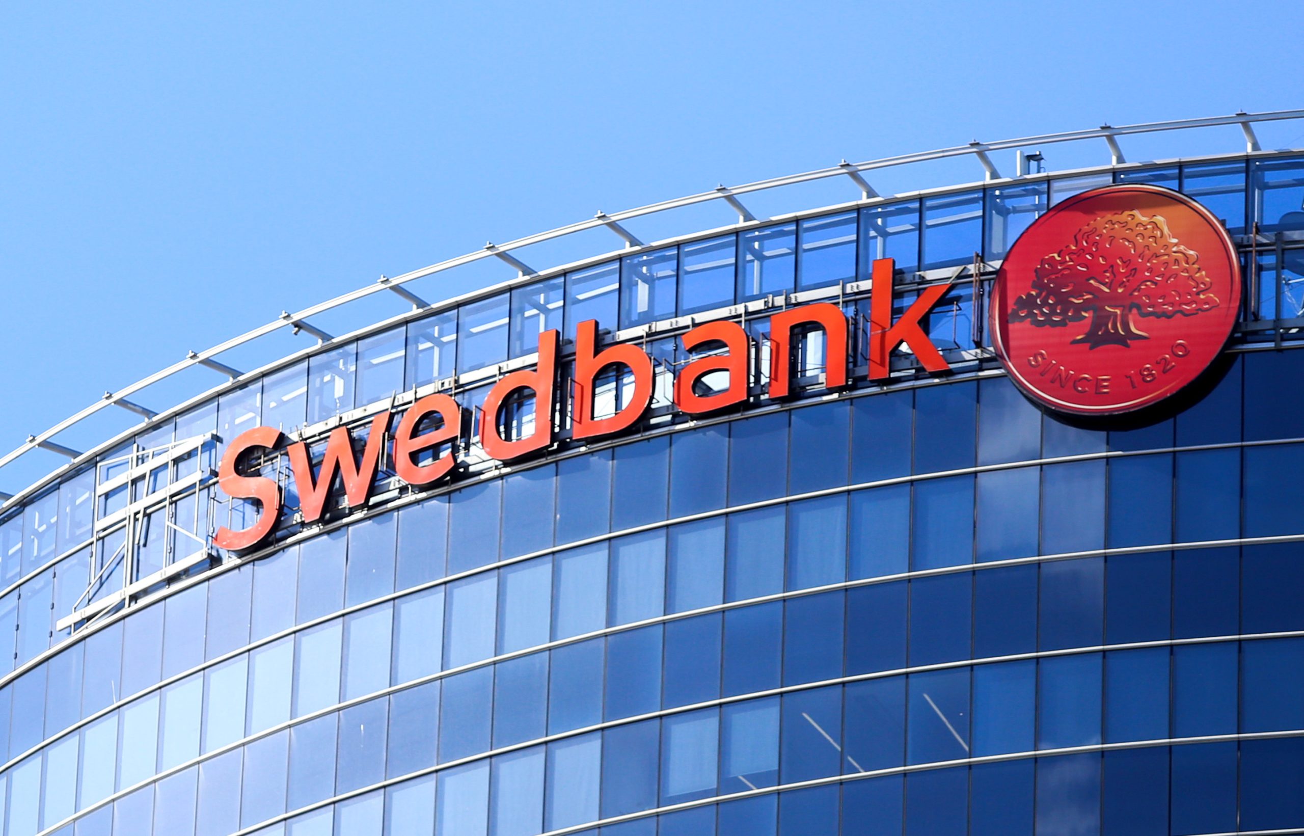 Swedbank logotips uz augstceltnes stiklotās fasādes