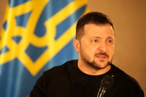 Ukrainas prezidents Volodimirs Zelenskis, runājot pie Ukrainas karoga.