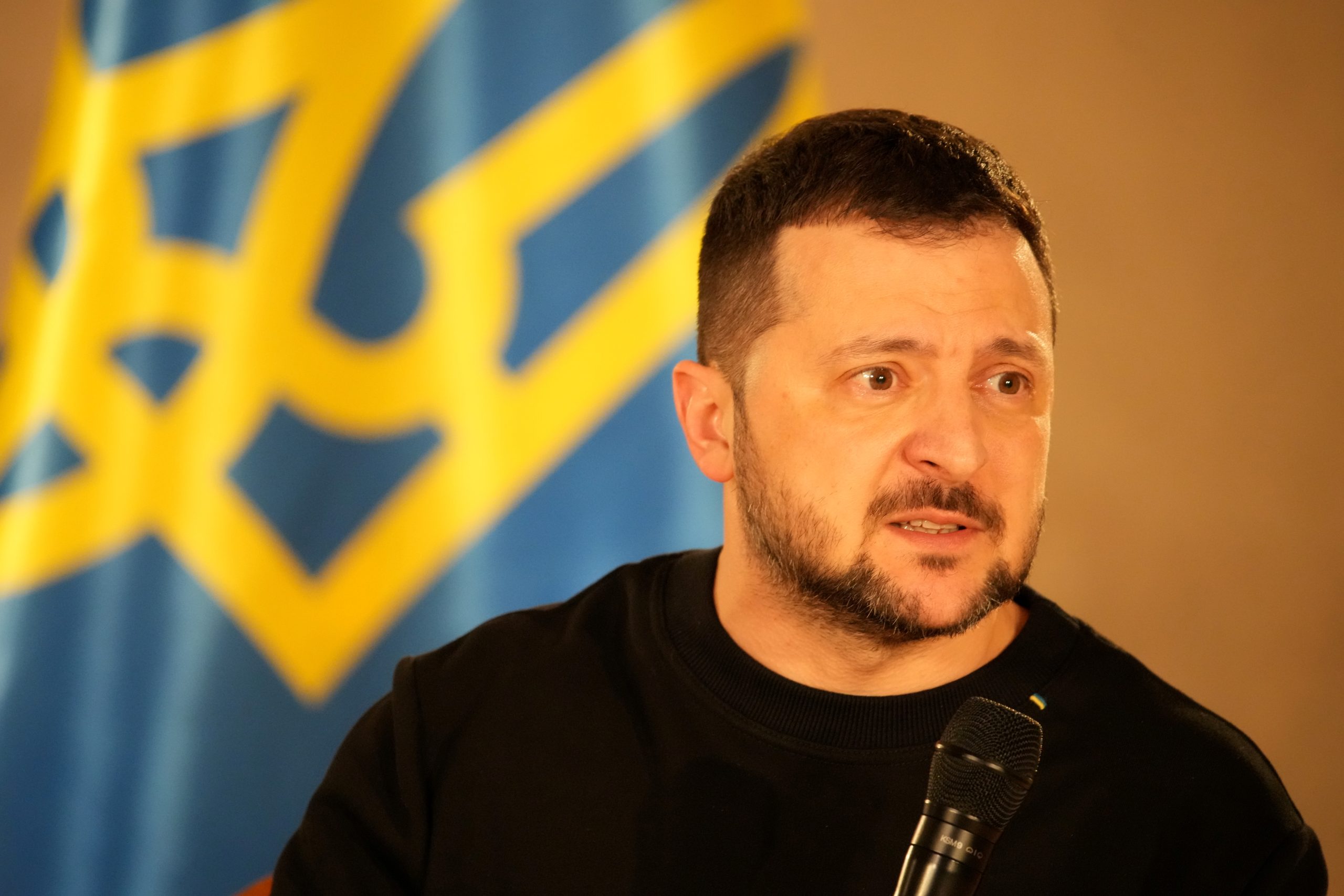 Ukrainas prezidents Volodimirs Zelenskis, runājot pie Ukrainas karoga.