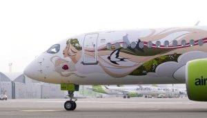 AirBaltic lidmašīna ar latvisku dizainu: uz tās attēlota sieviete ar ziedu vainagu un bezdelīgām, simbolizējot Latvijas dabu un kultūru.