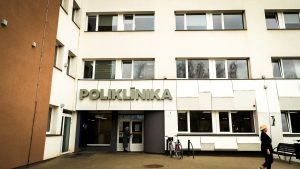 Mūsdienīga poliklīnikas ēka ar ieeju un uzrakstu Poliklīnika