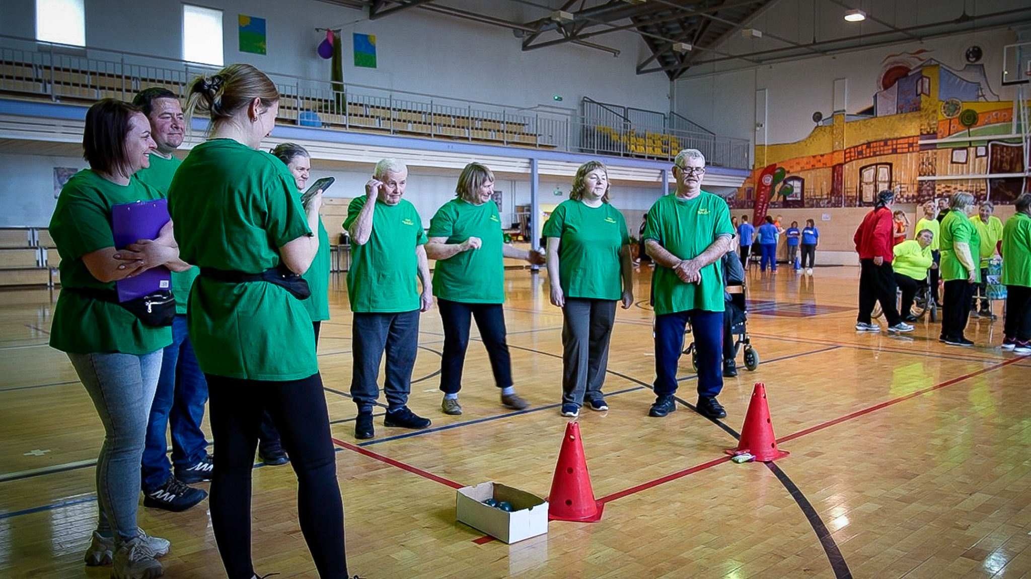 Senioru komanda zaļos krekliņos sporta pasākumā iekštelpās