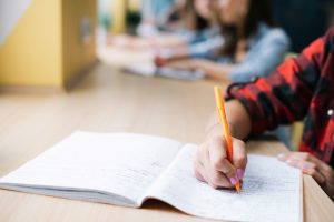 Students raksta piezīmes kladē lekciju laikā.