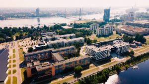 Rīgas Tehniskās universitātes Ķīpsalas kampuss ar Daugavu un Rīgas centru fonu