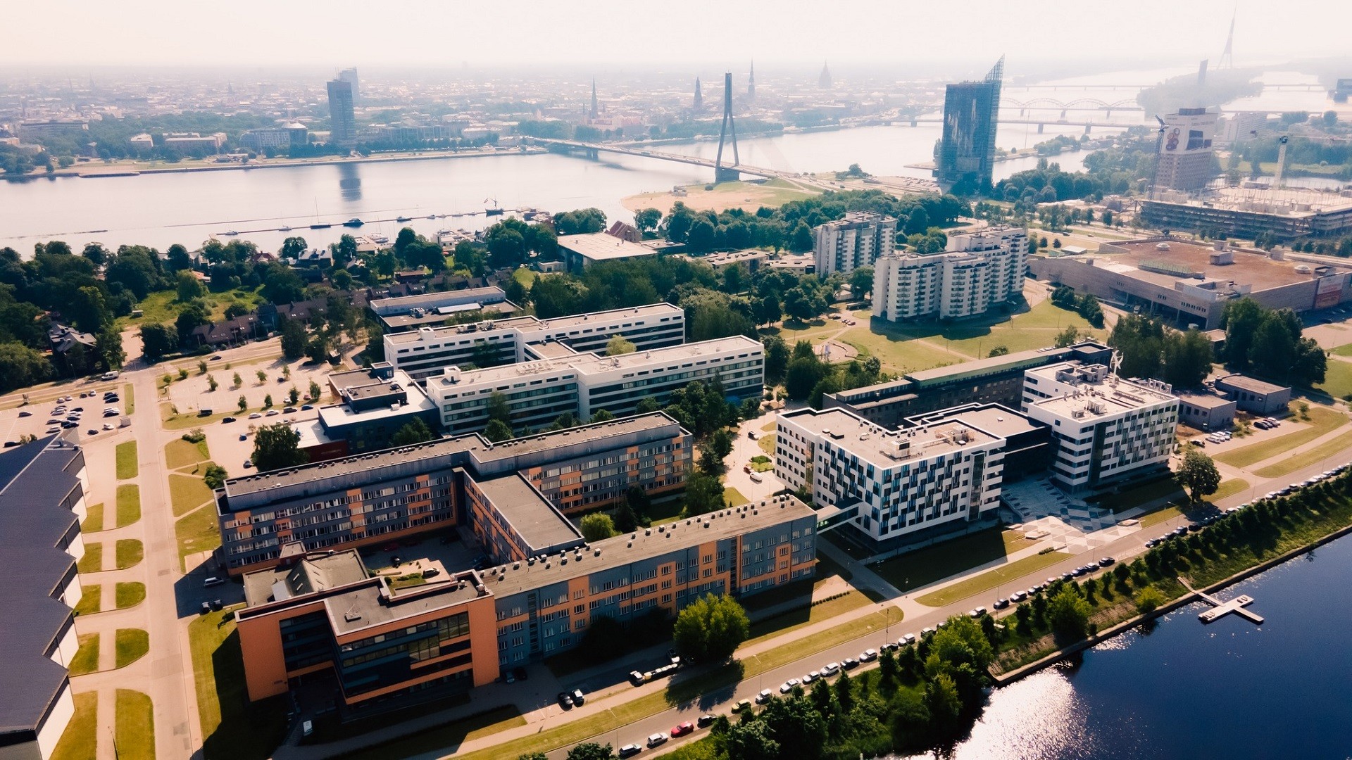 Rīgas Tehniskās universitātes Ķīpsalas kampuss ar Daugavu un Rīgas centru fonu