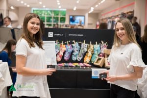 Divas jaunas uzņēmējas prezentē savu batikoto zeķu zīmolu COSMOZ JA Latvia pasākumā