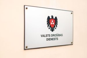 Valsts drošības dienesta plāksne ar ģerboni uz ēkas sienas