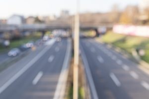 Aizmiglots skats uz daudzjoslu ceļu pilsētā ar automašīnu kustību