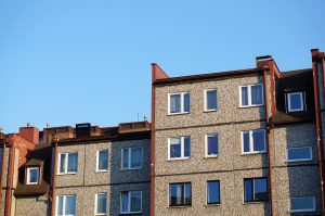 Dzīvokļu māju fasāde pret skaidri zilām debesīm