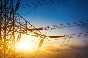 Augstsprieguma elektrolīniju tornis saulrietā.