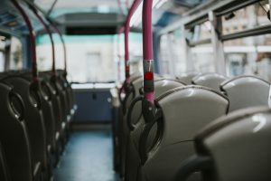 Tukšs sabiedriskais autobuss ar rindā izvietotiem sēdekļiem.