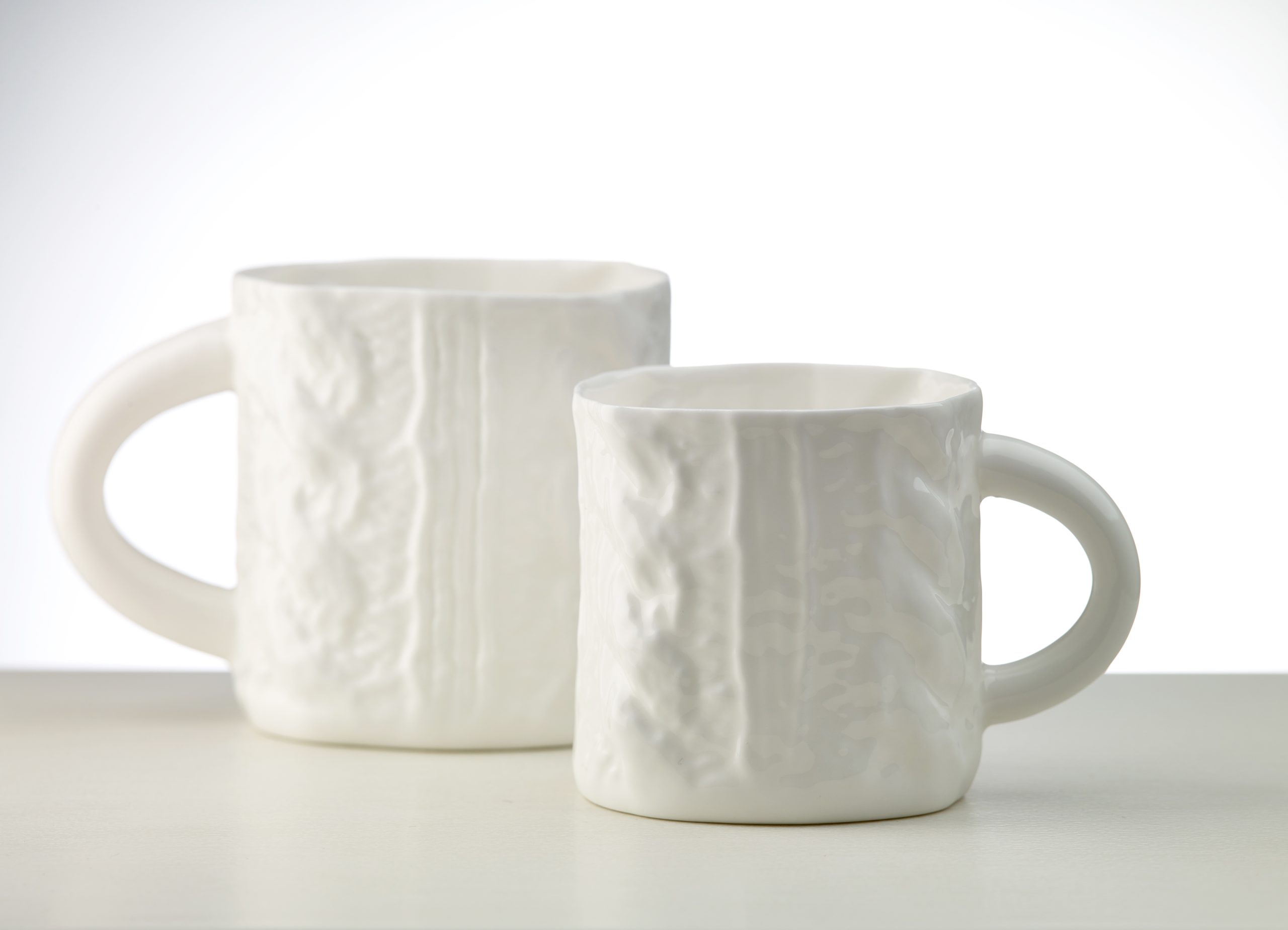Divas baltas porcelāna krūzes ar reljefu tekstūru