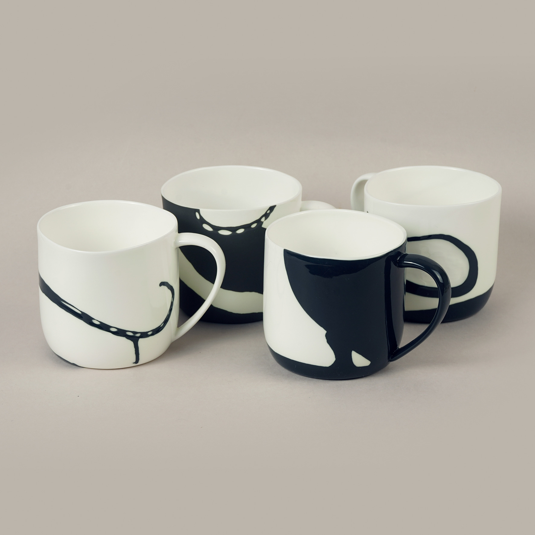 Četras porcelāna krūzes ar melnbaltiem abstraktiem rakstiem