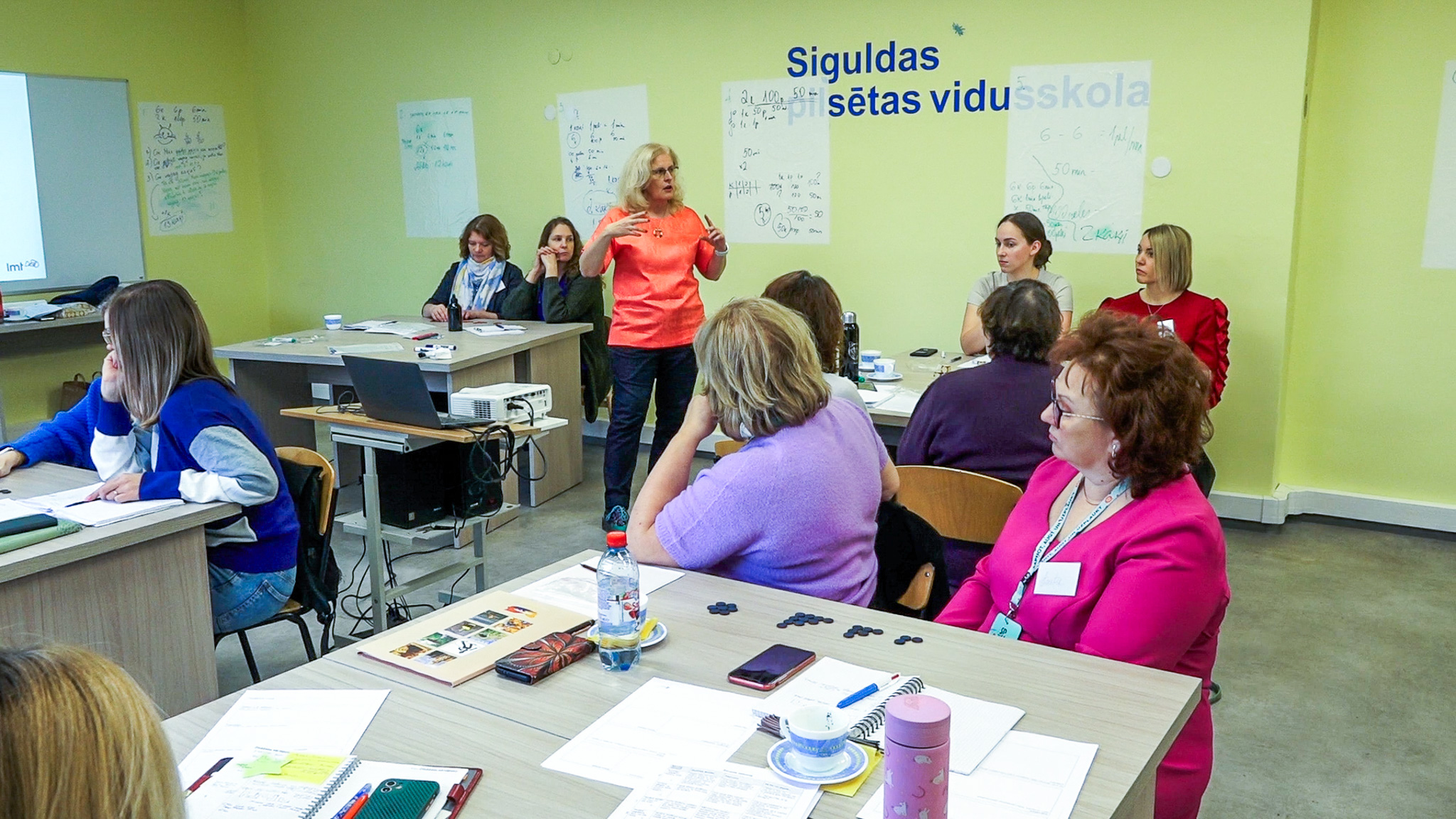 Skolotāju seminārs Siguldas vidusskolā, kur pasniedzēja vada nodarbību pie galdiem sēdošu dalībnieku grupai
