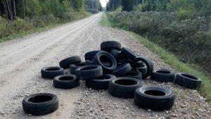 Nolietotas riepas izmestas uz meža ceļa Latvijas laukos.