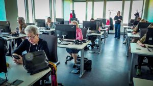Senioru grupa apgūst datorprasmes mūsdienīgā klasē ar pasniedzēju