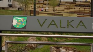 Metāla norāde ar uzrakstu "VALKA" un Valkas ģerboni