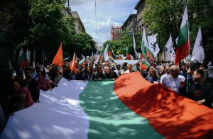 Protesta gājiens ar cilvēkiem, kas nes Bulgārijas karogu