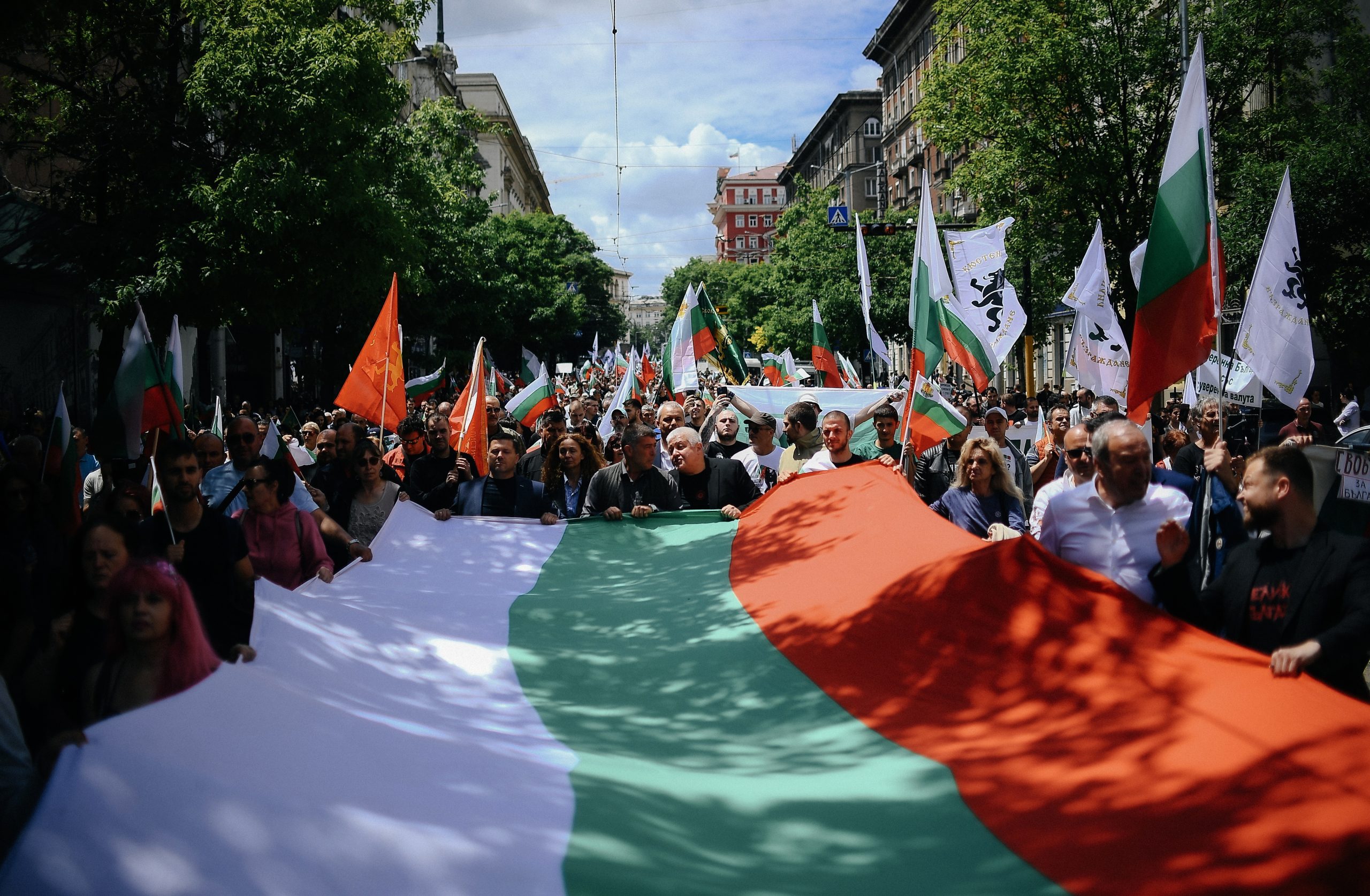 Protesta gājiens ar cilvēkiem, kas nes Bulgārijas karogu