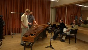 Jaunieši meistarklasē apgūst marimbas spēli, pedagogs sniedz norādes.