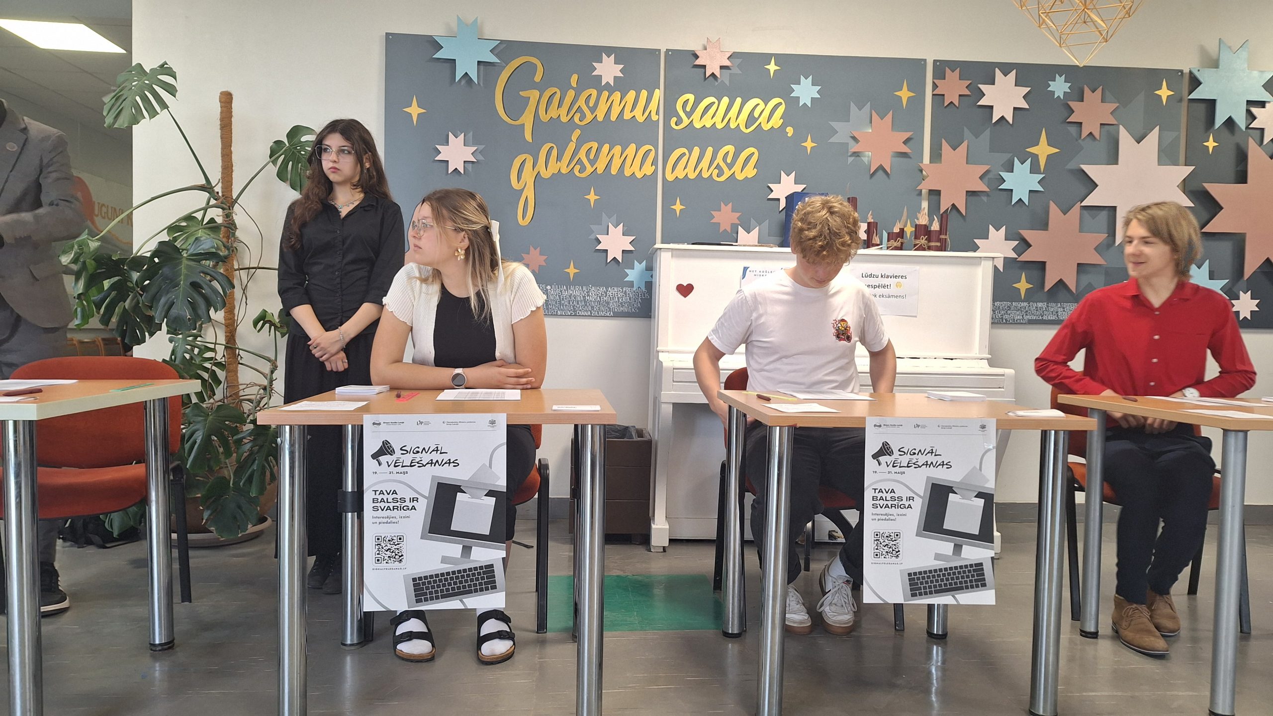 Jaunieši pie vēlēšanu reģistrācijas galdiem Jelgavas Spīdolas Valsts ģimnāzijā