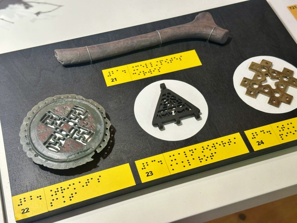 Dažādi arheoloģiski artefakti, tostarp kauls, metāla un koka priekšmeti ar Braila raksta apzīmējumiem.