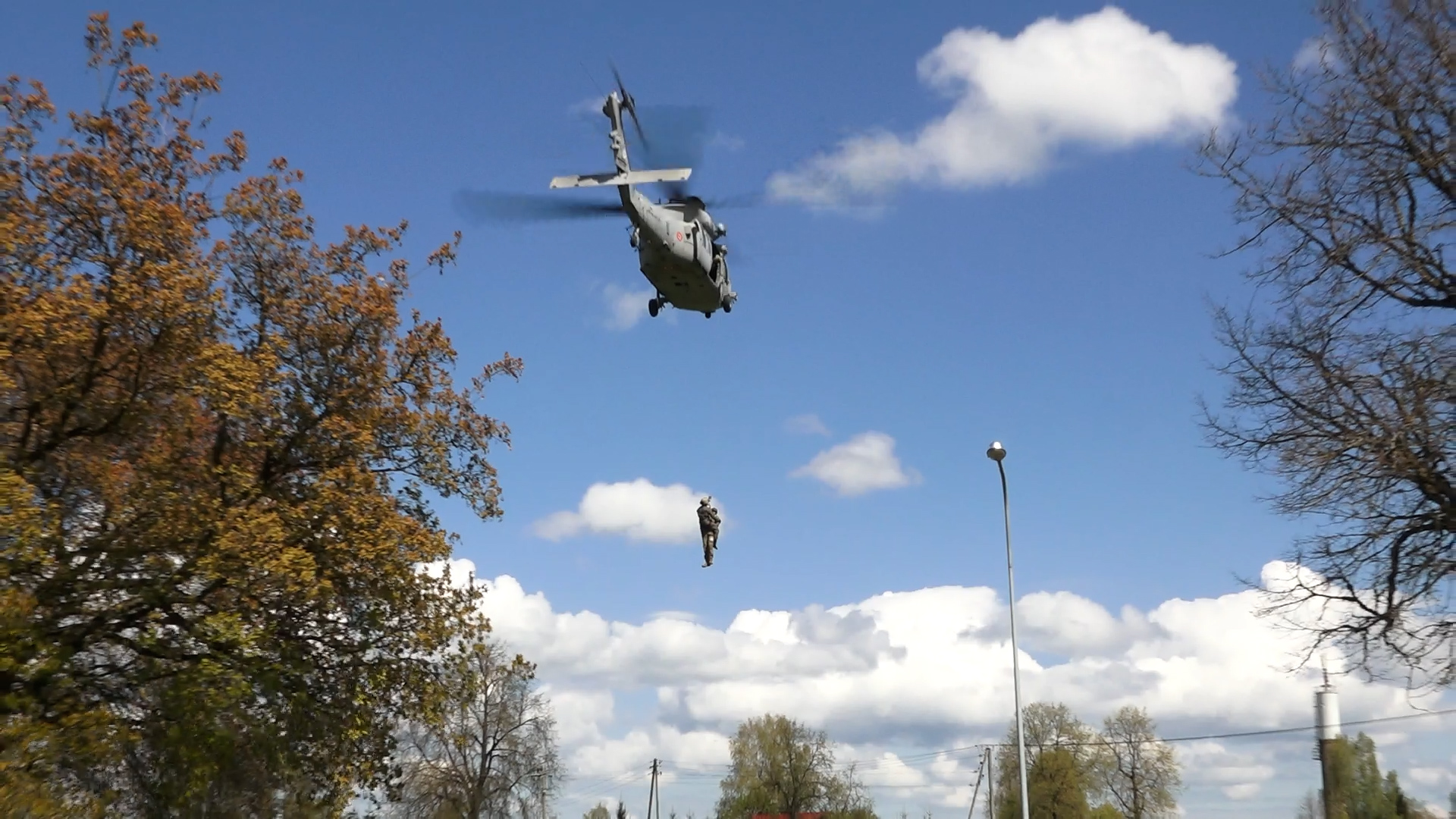 Militārais helikopters nolaižas, lai veiktu ievainotā karavīra medicīnisko evakuāciju mācību laikā.