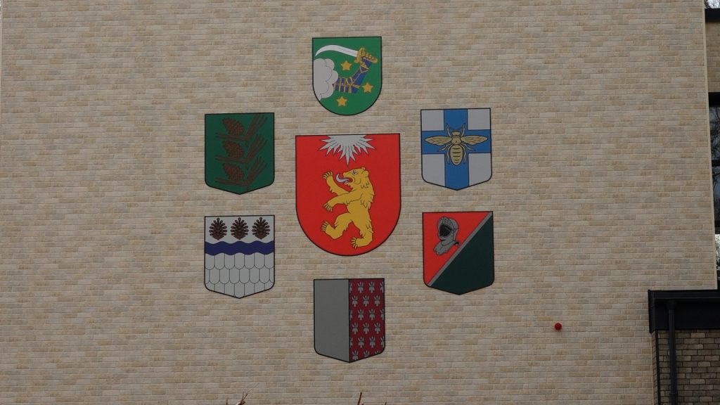 Deviņi ģerboņi uz Valkas novada domes ēkas fasādes
