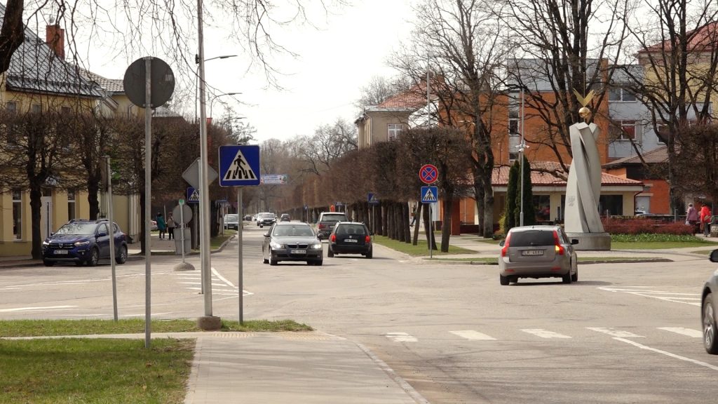 Iela Valkā ar automašīnām un ceļa zīmēm