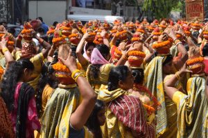 sievietes tradicionālos tērpos ceremonijā ar podiņām uz galvas