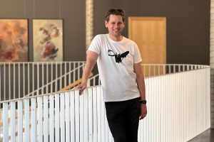 Vīrietis smaidīgi pozē modernā interjerā – Edgars Kaplers dalās pieredzē ar Krona slimību