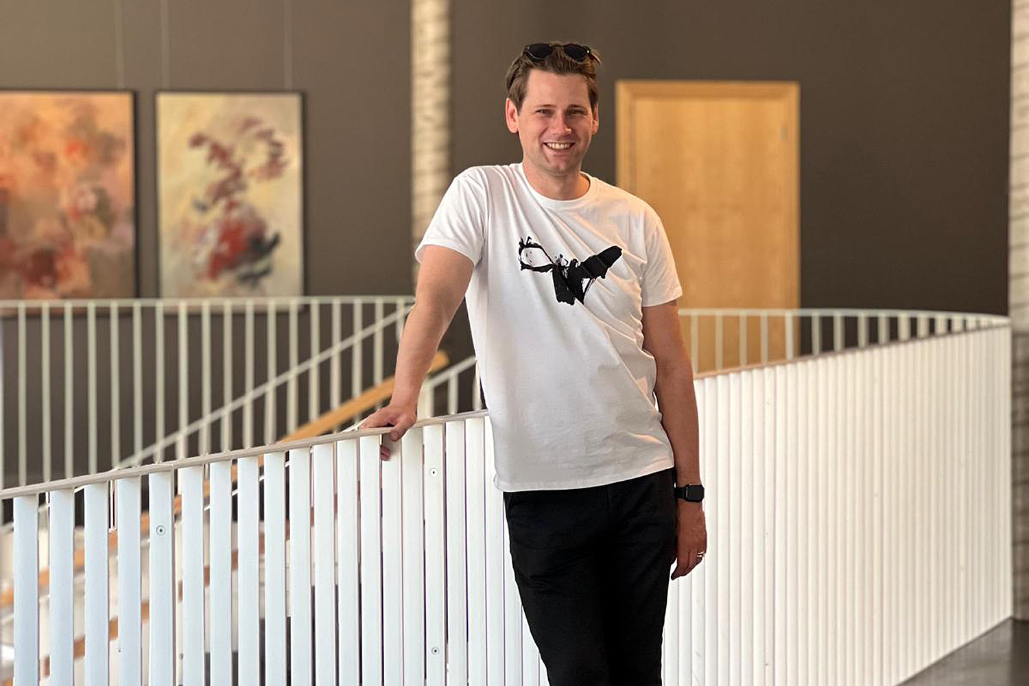 Vīrietis smaidīgi pozē modernā interjerā – Edgars Kaplers dalās pieredzē ar Krona slimību