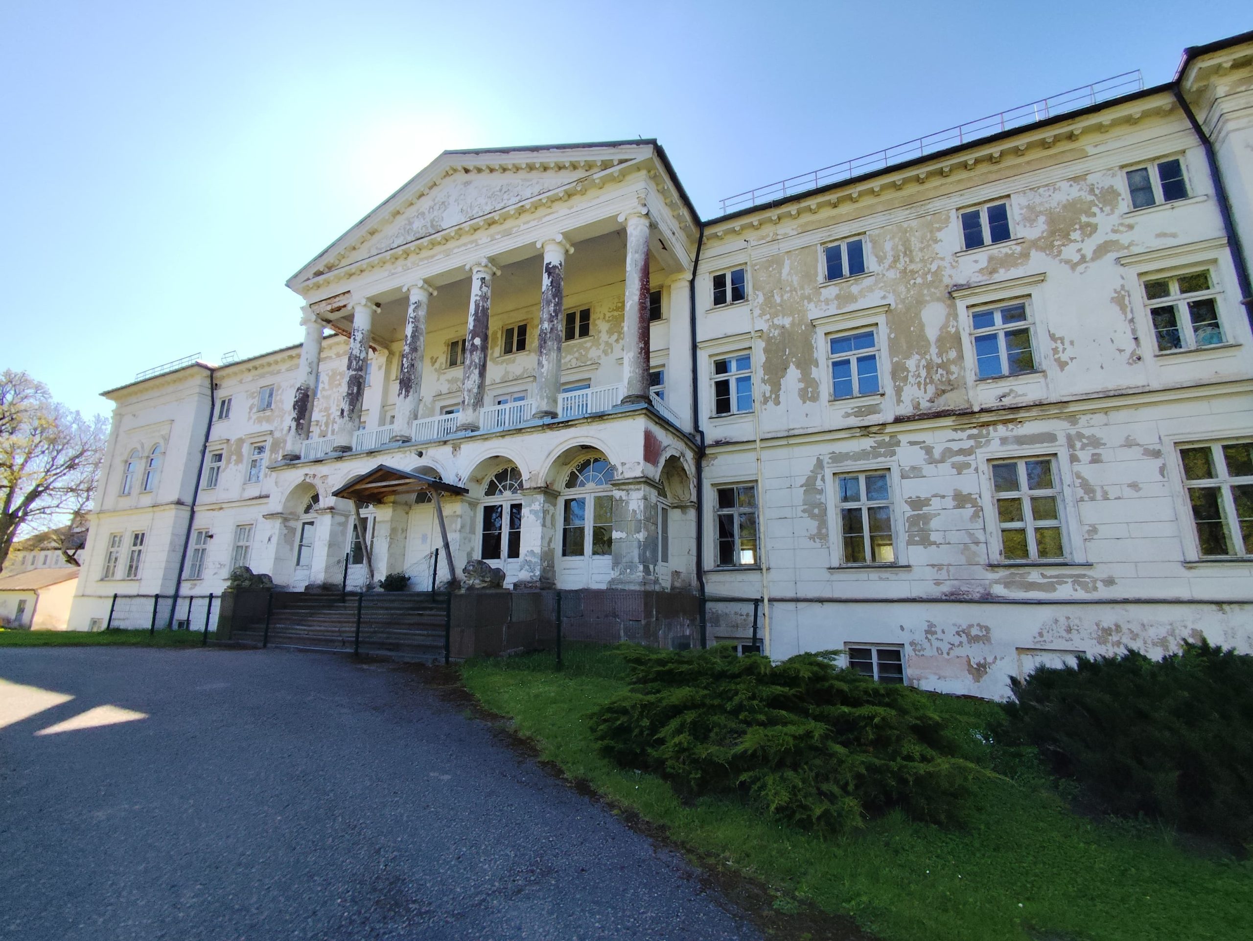 Gaujienas pils fasāde ar kolonnām un nolupušu apmetumu