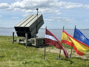 NATO pretgaisa aizsardzības sistēma NASAMS ar Latvijas, Spānijas un NATO karogiem, uzstādīta pie ūdenstilpes mācību "Latvian Shield 25" ietvaros