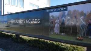 Bauskas novada informatīvais stends ar uzrakstu “Radošie un darošie” un sievietēm tautastērpos