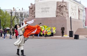 Latviešu tautastērpos tērpti dejotāji izpilda deju pie Brīvības pieminekļa Rīgā