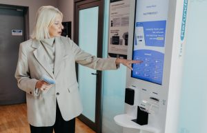 Sieviete izmanto pašapkalpošanās automātu