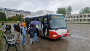 Skolēni lietainā dienā iekāpj vecā autobusā pie Salas vidusskolas