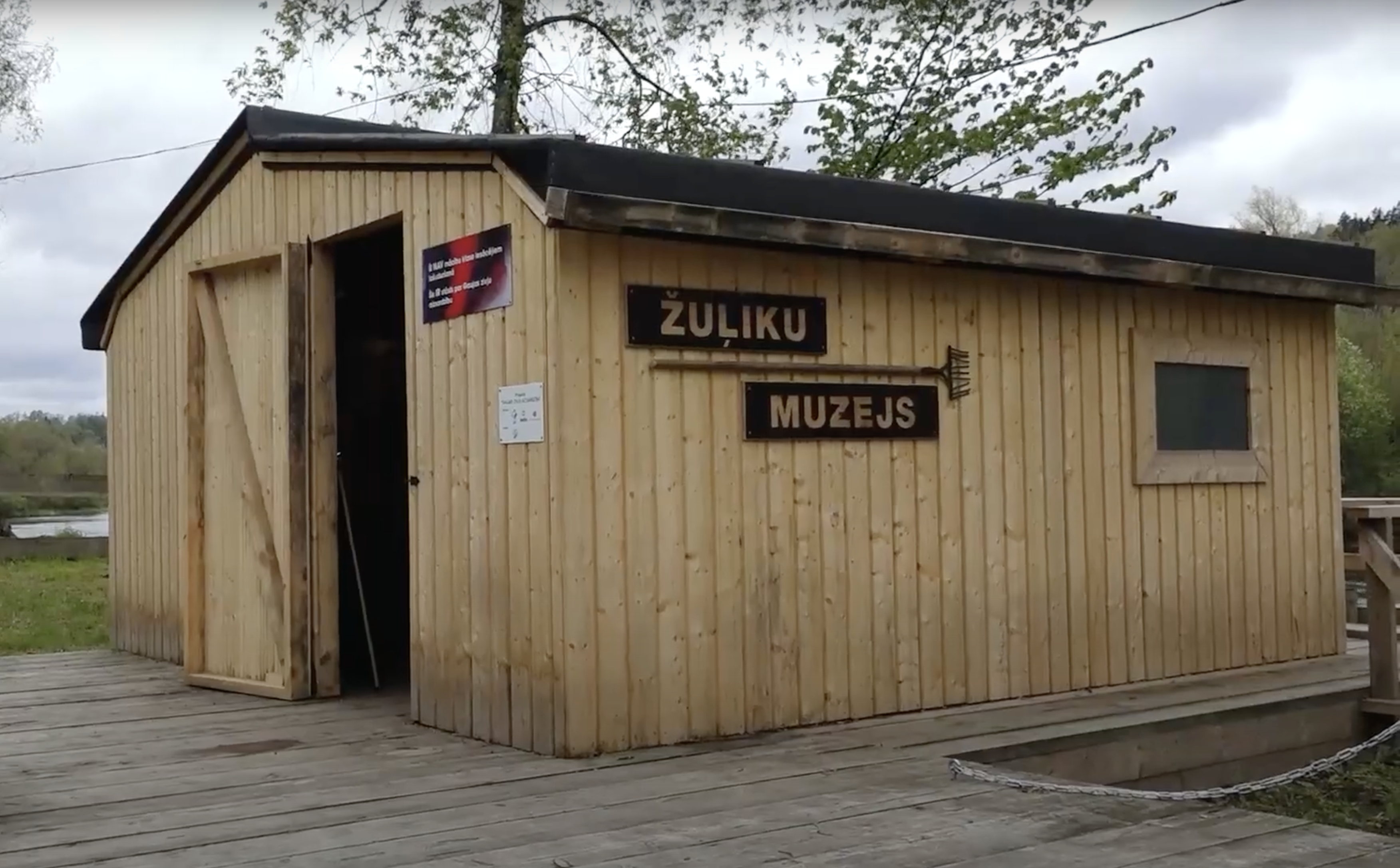 Koka ēka ar uzrakstu “Žuļiku muzejs” Latvijas vidē