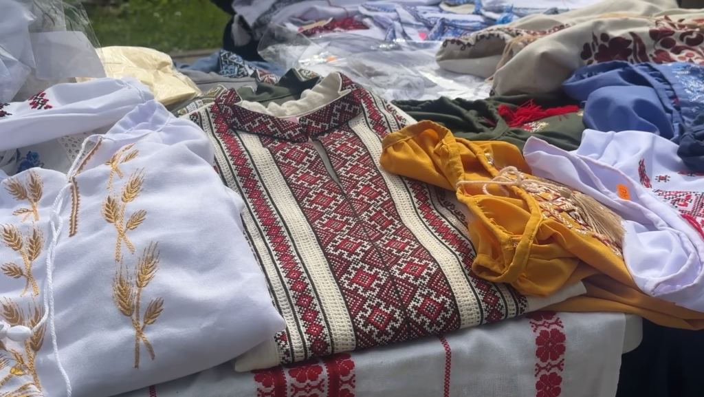Tuvplāns ar izšūta krekla detaļu ar vienkāršāku, brūnganu ornamentu