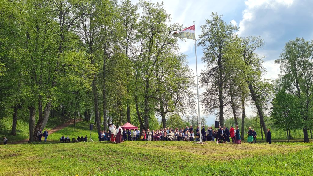 Plašs skats uz Sēlijas dienas svinībām Sunākstes parkā ar karogu un pulcējušos tautu