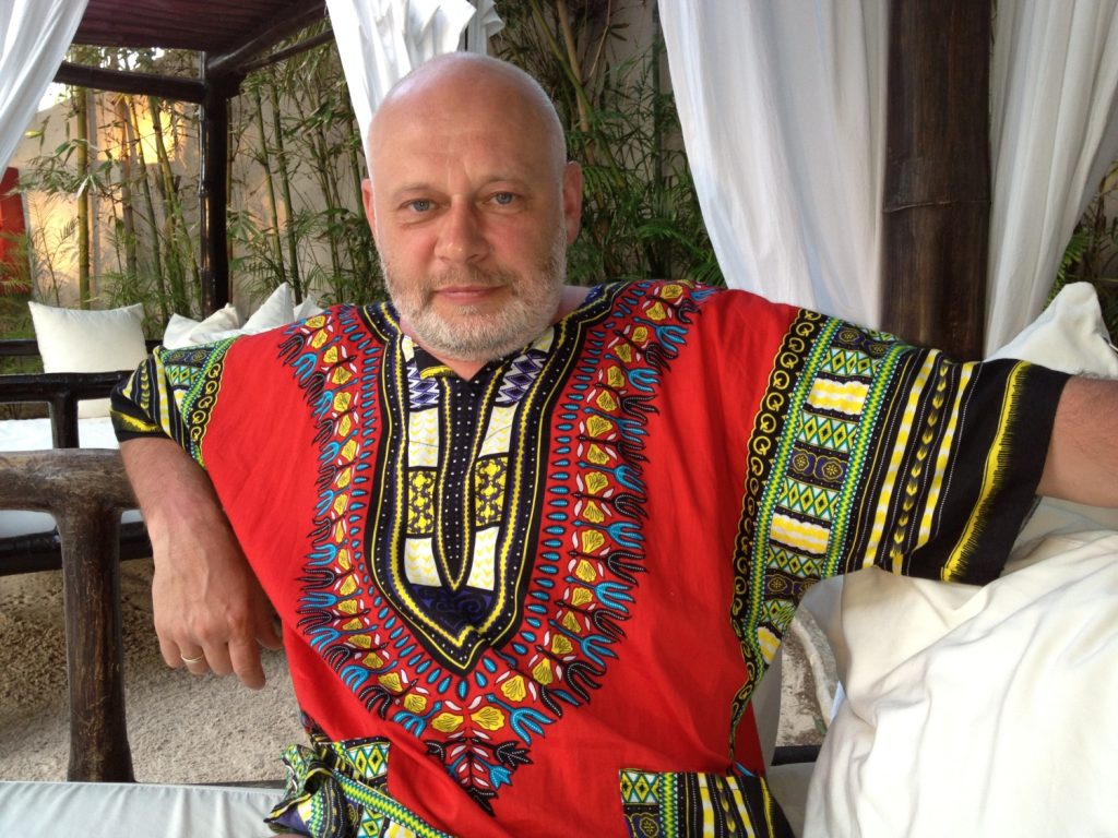 Astrologs Aleksandrs Sokolovs, sēžot ar dashiki kreklu