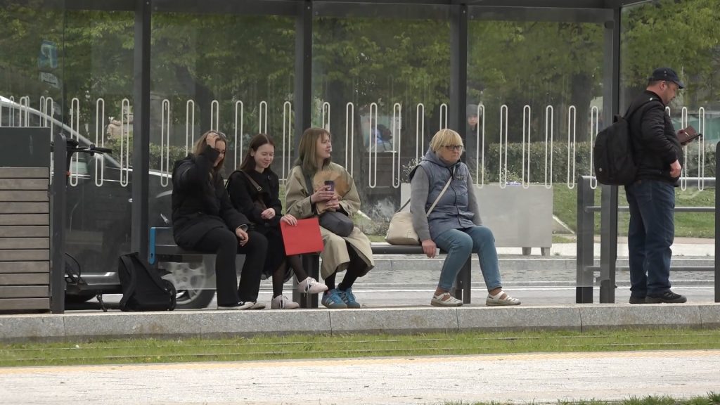 Cilvēki gaida sabiedrisko transportu pieturā Liepājā