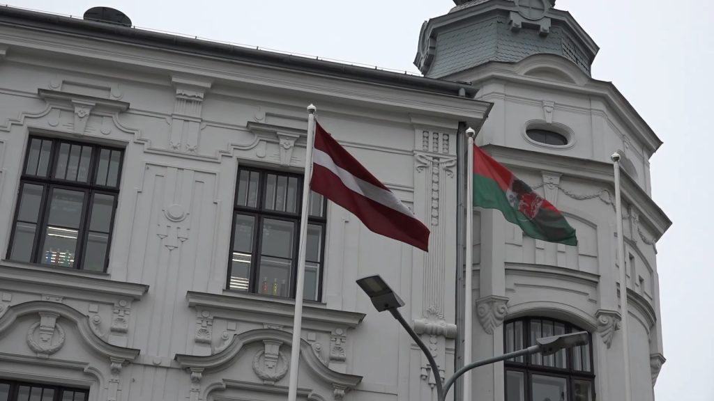 Pie ēkas plīvo Latvijas un Liepājas pilsētas karogi