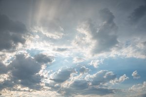 Saules stari caur mākoņiem debesīs