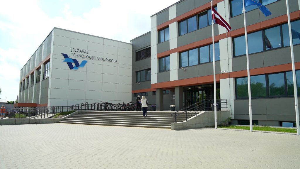 Jelgavas Tehnoloģiju vidusskolas ēka ar Latvijas un Jelgavas karogiem